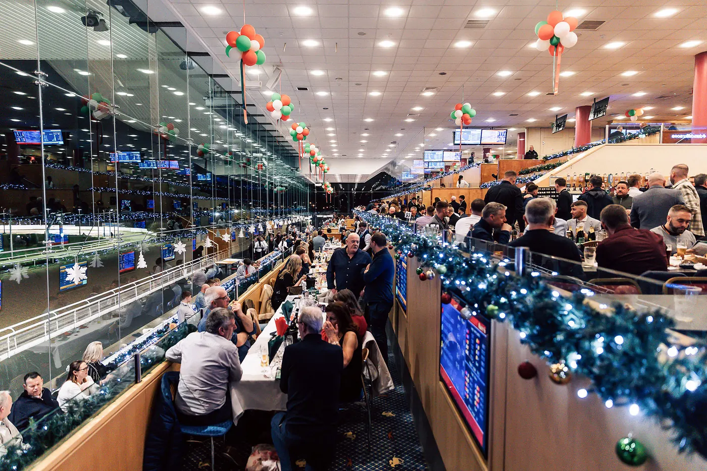 A guest checking the race card at a festive table.