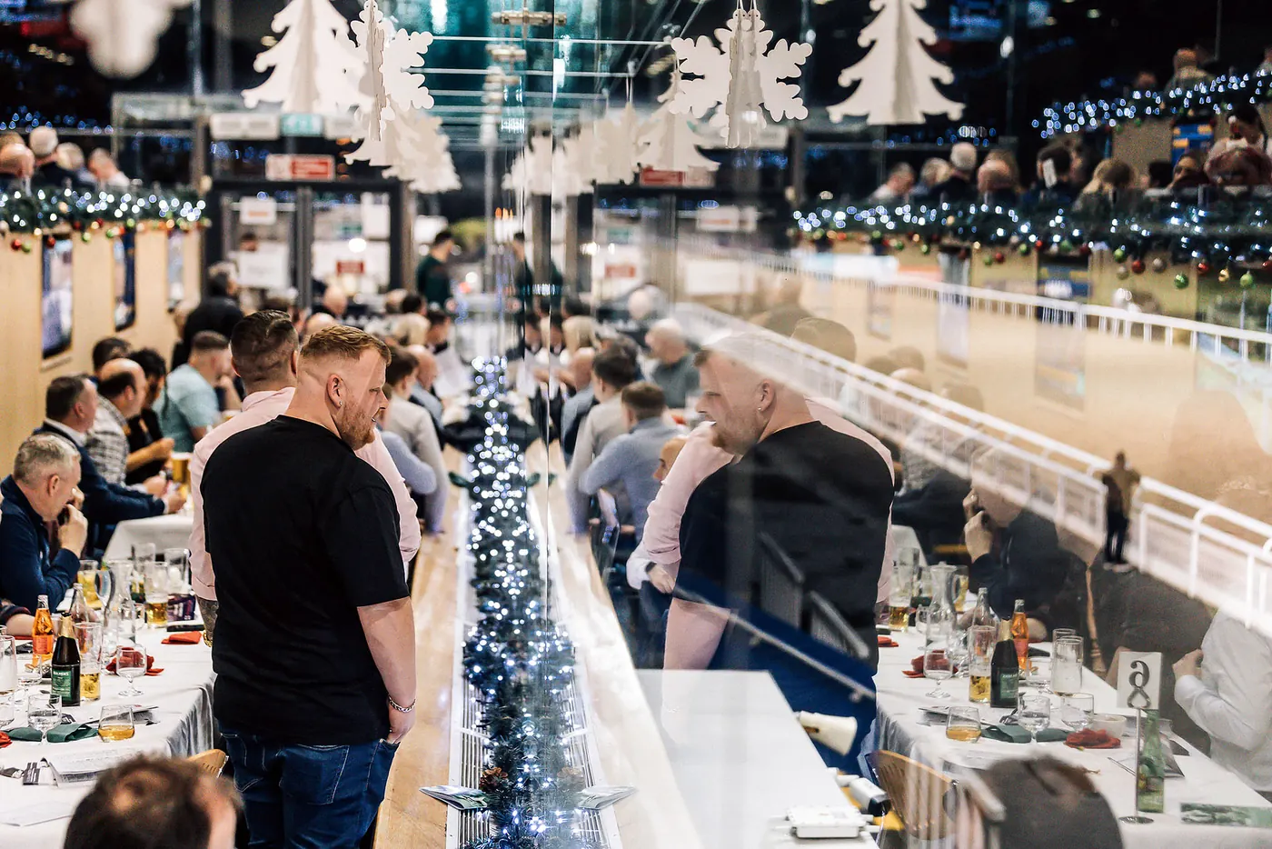 Friends laughing over dinner at Christmas at the Races.